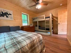 a bedroom with two bunk beds in a log cabin at Blissful Bear in Old Forge