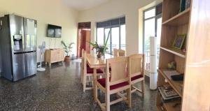 a kitchen with a table and chairs and a refrigerator at Nile retreat in Jinja