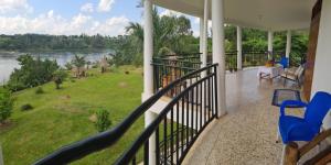 a balcony with chairs and a view of a river at Nile retreat in Jinja
