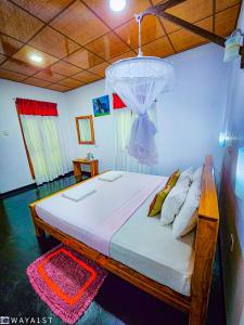 1 dormitorio con 1 cama con lámpara de araña encima en Sunbird's Home, en Udawalawe