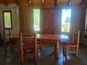 a wooden table and chairs in a room at Complejo Turístico PET Friendly Los Abuelos- Cabaña ENCANTO NATURAL. in Cholila