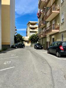 uma rua com carros estacionados ao lado de um edifício em Casa Maria em Milazzo