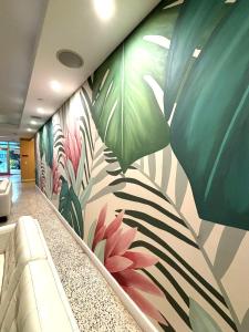 a lobby with a mural of plants on the wall at Collins Hotel in Miami Beach