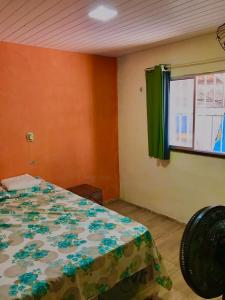 een slaapkamer met een bed en een raam met een groen gordijn bij Recanto Girassol in Aquiraz