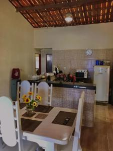 een keuken met een tafel en stoelen en een keuken met een aanrecht bij Recanto Girassol in Aquiraz