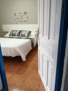 1 dormitorio con 1 cama con edredón blanco en Reposo tranquilo en entorno rural, en Cetina