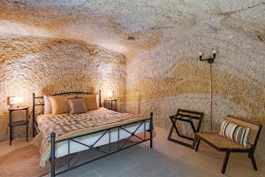 1 dormitorio con 1 cama en una pared de piedra en La Cantina, en Demjén