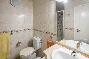 a bathroom with a toilet and a sink and a tub at Maio Apartment in Luz +10 photos
