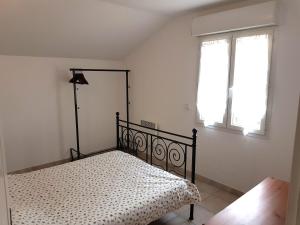 a bedroom with a bed in a room with a window at Gîte du Pont Bailey in Tulette
