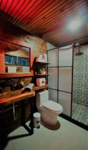 a bathroom with a toilet and a wooden counter at El Refugio in Quindío