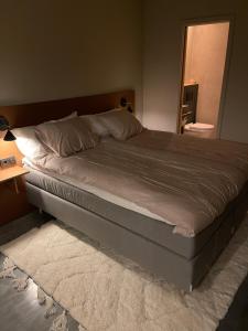 a large bed in a bedroom with a table and a mirror at Chambre hotell in Stockholm