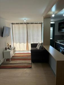 ein Wohnzimmer mit einem Sofa und einem Fenster in der Unterkunft Acogedor departamento arica in Arica