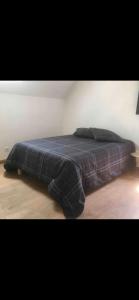 een bed met een blauwe deken erop bij Maison récente très spacieuse in Forges-les-Bains +10 foto's