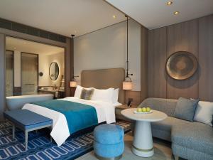 a hotel room with a bed and a couch at City of Dreams Mediterranean - Integrated Resort, Casino & Entertainment in Limassol