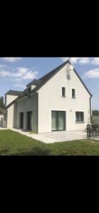 een groot wit gebouw met ramen aan de zijkant bij Maison récente très spacieuse in Forges-les-Bains