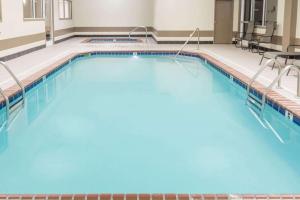 a large swimming pool with blue water in a building at Quality Inn in Huntington