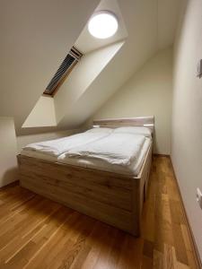 łóżko w pokoju ze skośnym sufitem w obiekcie Villa S. Gallen w mieście Liptowskie Matiaszowce