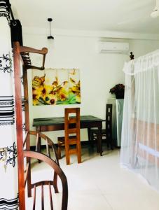 a dining room with a table and a chair at Nasareth Villa Unawatuna in Galle