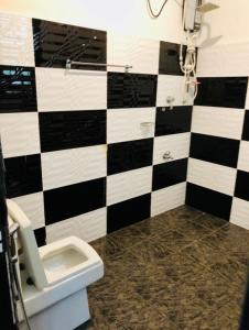 a bathroom with a black and white checkered wall at Nasareth Villa Unawatuna in Galle