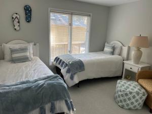 1 dormitorio con 2 camas y ventana en Palmetto Breeze, Golf Course New furniture, carpet, en Johns Island