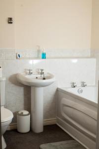 Avril Warwickshire Home Stay في نيونياتون: حمام مع حوض ومرحاض