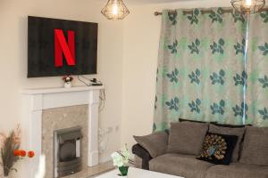 sala de estar con sofá y chimenea en Avril Warwickshire Home Stay, en Nuneaton