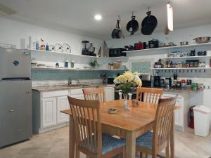 uma cozinha com uma mesa de madeira com cadeiras e um frigorífico em Private Guest House 2 bedrooms & 2 baths near Grace Bay Beach & Long Bay Beach. em Providenciales