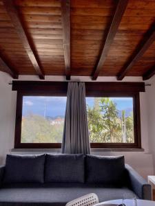 a couch in a living room with a large window at Casa Vacanza Porta Smeralda in Olbia