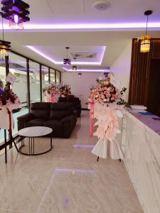 uma sala de estar com sofás, mesas e flores em One Dream Hotel em Petaling Jaya
