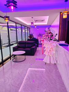 a purple room with couches and a table and flowers at One Dream Hotel in Petaling Jaya