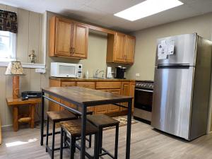 a kitchen with a table and a stainless steel refrigerator at Ryder's Lodge in Old Forge