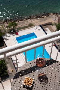 una mesa con una copa de vino y aperitivos en el balcón en Hotel Delfino Taranto, en Taranto