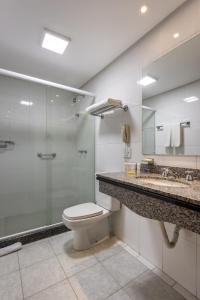 uma casa de banho com um WC e uma cabina de duche em vidro. em Blue Tree Towers Millenium Porto Alegre em Porto Alegre