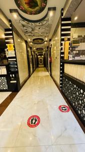 długi korytarz z podłogą wyłożoną kafelkami w budynku w obiekcie أجنحة بلو روز الفندقية w mieście Nadżran