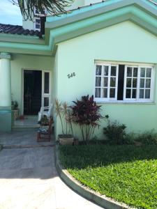 a white house with a porch and a chair at Pousada Sossego in São Gabriel