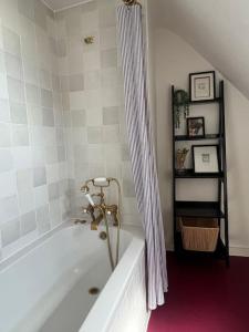 a bathroom with a bath tub with a shower curtain at The Turret- the best view in Folkestone in Folkestone