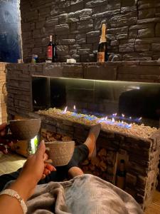 a person sitting in front of a fireplace with their feet up at Turmequé cabaña 