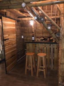 a bar in a wooden cabin with two stools at Turmequé cabaña 
