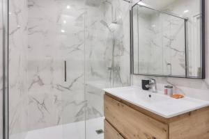 a white bathroom with a sink and a shower at Très bel appartement pour 4 aux portes de Paris in Aubervilliers