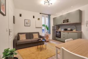 a living room with a couch and a kitchen at Très bel appartement pour 4 aux portes de Paris in Aubervilliers