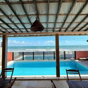 a swimming pool with a view of the ocean at B&B Beach House Pousada Exclusiva pés na água Pontal do Peba única em Alagoas in Pontal do Peba