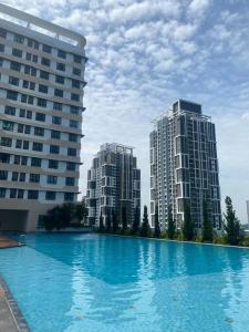 two tall buildings next to a large swimming pool at 3 Bed Backpack Edusphere Suite in Cyberjaya