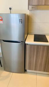 a kitchen with a stainless steel refrigerator and cabinets at 3 Bed Backpack Edusphere Suite in Cyberjaya
