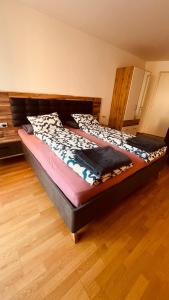 Cama grande en habitación con suelo de madera en Appartement Nadia, en Bresanona