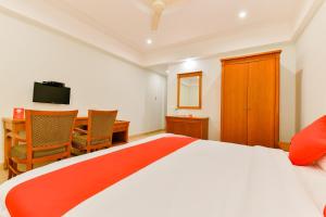 a bedroom with a bed and a table and a desk at Vembanad Tourist Home in Vaikom