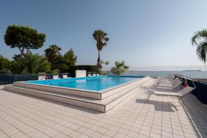 uma piscina com bancos à volta num pátio em Hotel Delfino Taranto em Taranto