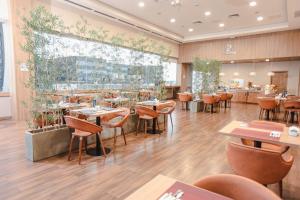 un restaurante con suelo de madera, mesas y sillas en Paseo La Galería Hotel & Suites, en Asunción