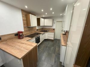 eine Küche mit weißen Schränken und Arbeitsplatten aus Holz in der Unterkunft Ferienwohnung Supp in Zweibrücken