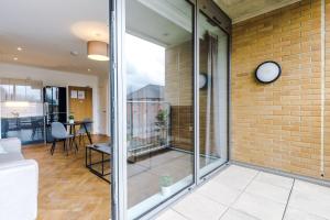 um quarto com portas de vidro e uma parede de tijolos em Hilltop Serviced Apartments - Ancoats em Manchester