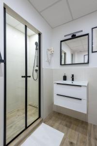 een badkamer met een douche, een wastafel en een spiegel bij Budapest Holidays OPERArt in Boedapest